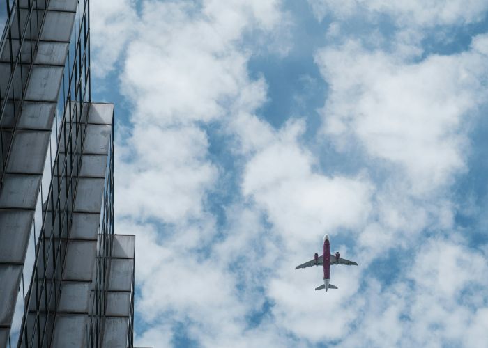 A plane flying through a cloudy sky.